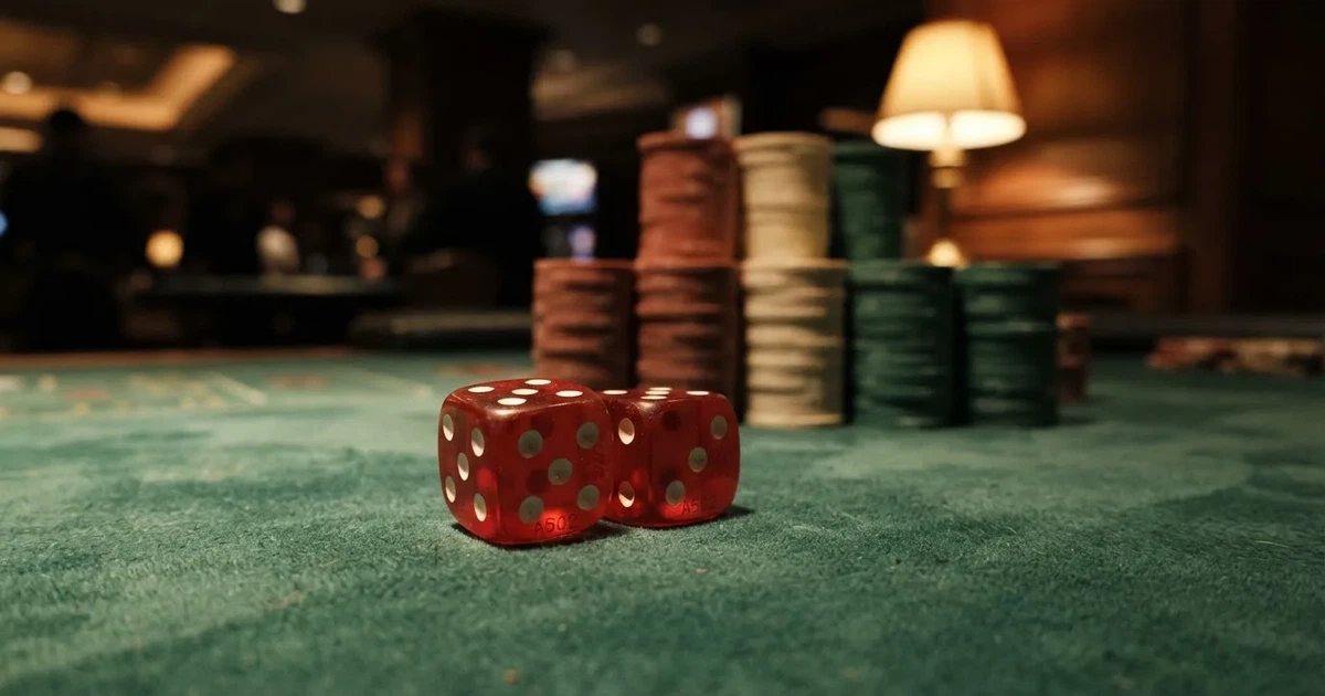 Röda tärningar vilar på grönt filt, bakom dem suddiga torn av spelmarker i kvällsdunklet — svenska internet casinon